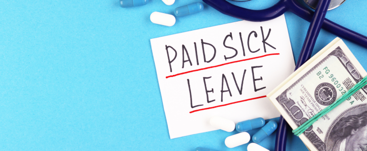 Paid sick leave written on a note next to a stethoscope and money
